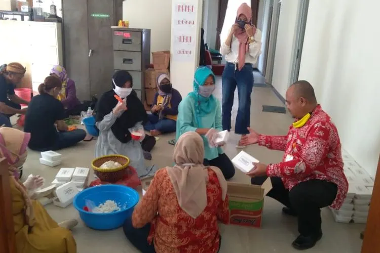 Warga tengah menyiapkan nasi boks untuk dibagikan ke masyarakat terdampak Covid-19 di Bogor. (Ayobogor/Husnul Khatimah)