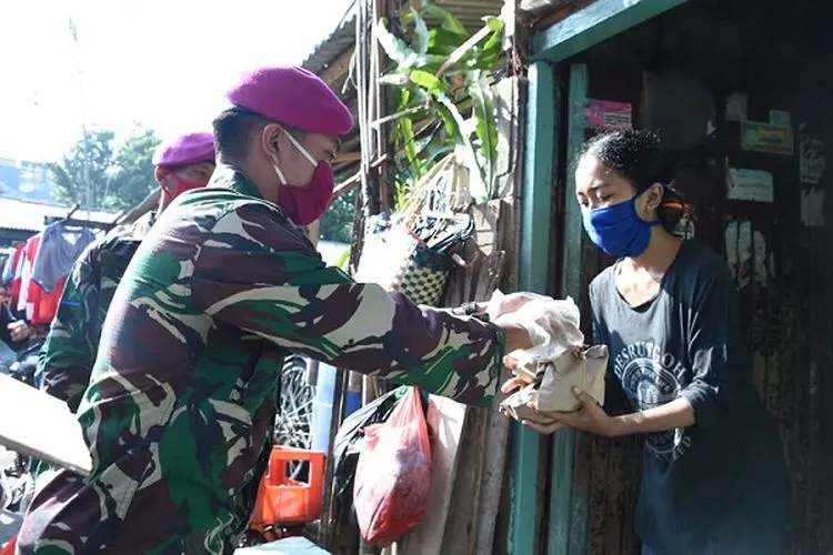 Prajurit TNI membagikan nasi bungkus dari rumah ke rumah warga di Kelurahan Baru, Tebet, Jakarta Selatan, Rabu (22/4/2020). (Puspen TNI)