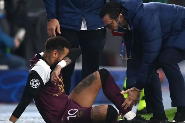Penyerang PSG, Neymar mendapatkan perawatan usai mengalami cedera pada laga Liga Champions 2020/2021 kontra Istanbul Basaksehir di Basaksehir Fatih Terim Stadyumu, Istanbul, Turki, Kamis (29/10/2020) dini hari WIB. [OZAN KOSE / AFP]