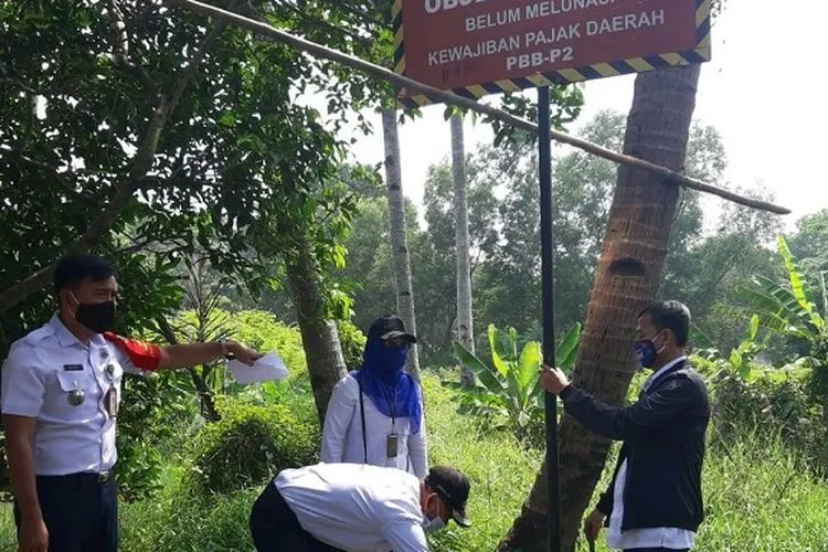 Jajaran Kecamatan Cipayung ketika memasang plang penunggak pajak (dok: timur.jakarta.go.id)