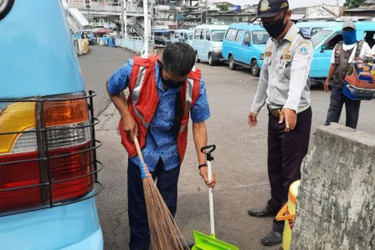 Pelanggar PSBB menyapu jalan di Terminal Kampung Melayu, Jakarta Timur (Beritajakarta.id/Nurito)