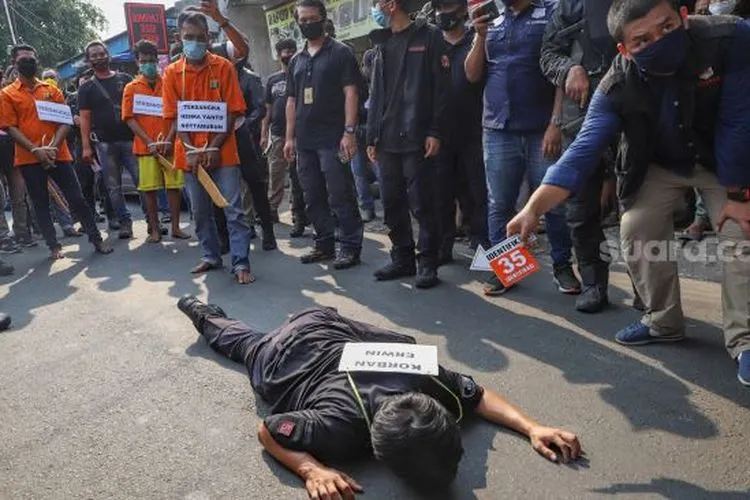 Korban Erwin yang jatuh tersungkur setelah dianiaya oleh kelompok John Kei saat rekonstruksi di Duri Kosambi, Jakarta Barat, Rabu (24/6). [Suara.com/Alfian Winanto]