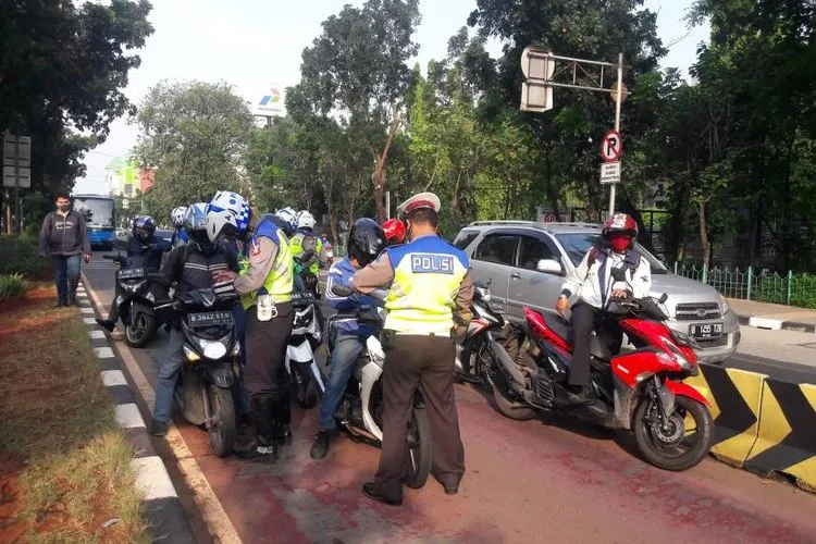 Para pengendara yang masuk ke jalur Transjakarta di Jalan Sutoyo, Jakarta Timur, Kamis (23/7), ditilang petugas polisi dalam Operasi Patuh Jaya 2020. (Foto: Meiliza Laveda)