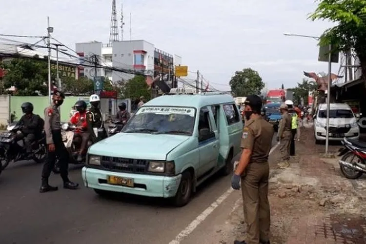 Petugas gabungan saat memeriksa pengendara di Check Point PSBB Pasar Rebo, Jaktim. (Suara.com/Bagaskara).