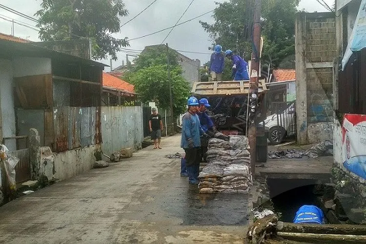 Petugas Tata Air Jakarta Timur tengah membersihkan saluran air di Utan Kayu Utara, Matraman, Jakarta Timur, Senin (2/3/2020) (Ayojakarta.com/Hendy Dinata)