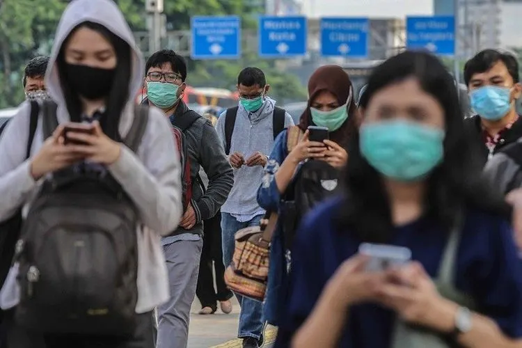Ilustrasi - Para pekerja menerapkan protokol kesehatan dengan menggunakan masker saat berjalan di trotoar kawasan Jalan Sudirman, Jakarta Pusat. (Media Indonesia/Ramdani)