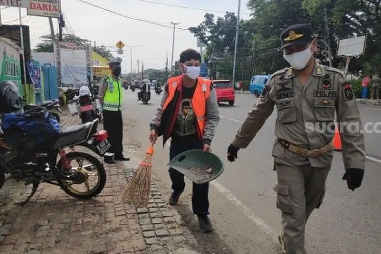 sebagai ilustrasi. Pelanggar PSBB yang dikenakan sanksi sosial oleh petugas di check point Pasar Rebo, Jaktim. (Suara.com/Bagaskara).