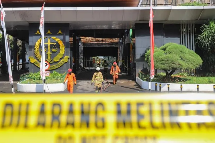 Petugas Damkar DKI berjalan keluar usai melakukan proses pendinginan di Gedung Utama Kejaksaan Agung RI di Jalan Sultan Hasanuddin, Jakarta Selatan, Minggu (23/8). [Suara.com/Alfian Winanto]