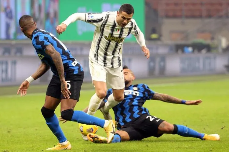 Pemain Inter Milan Arturo Vidal mencoba merebut bola dari pemain Juventus Cristiano Ronaldo dalam pertandingan lanjutan Liga Italia, Senin (18/1) dini hari. Foto: EPA