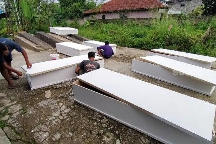 Sejumlah pekerja tengah membuat peti jenazah khusus Covid-19 di Kecamatan Cibungbulang, Kabupaten Bogor, Senin (4/5/2020). (Suara.com/Zian Alfath)