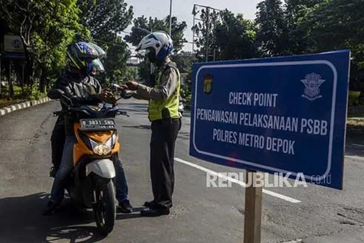 Polisi memeriksa identitas pengendara motor berboncengan yang akan menuju Jalan Raya Margonda saat hari pertama pemberlakukan Pembatasan Sosial Berskala Besar (PSBB) di perbatasan Jakarta dan Depok, Lenteng Agung, Jakarta, Rabu (15/4/2020). (Foto: Republika/Putra M Akbar)