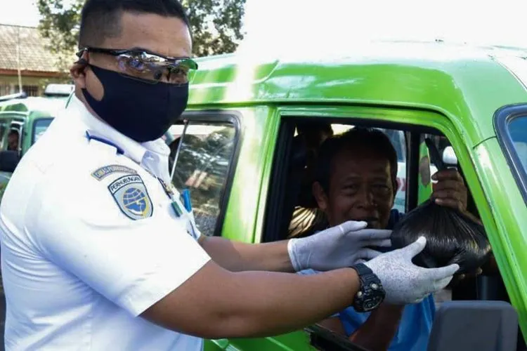 Petugas memeriksa suhu tubuh dan bantuan sembako kepada sopir angkot di Kota Bogor. Ist