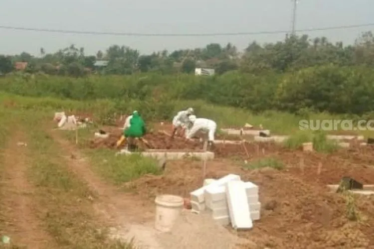 Para penggali kubur di TPU Buniayu, Kecamatan Sukamulya, Kabupaten Tangerang, tengah memakamkan jenazah Covid-19. [Suara.com/Ridsha Vimanda Nasution]