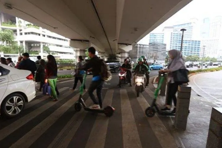 Pengguna skuter listrik melintas di kawasan Jalan Jenderal Sudirman, Jakarta Pusat. (Warta Kota/Angga Bhagya Nugraha)