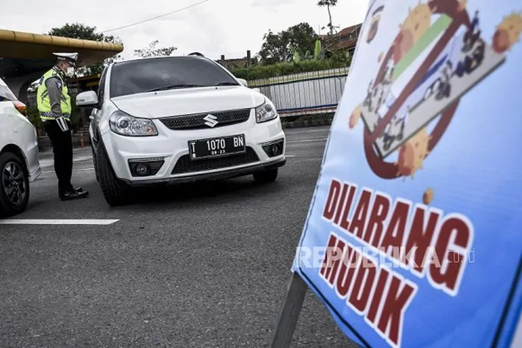 Petugas kepolisian mengarahkan kendaraan untuk memutar balik di pos pemeriksaan Pembatasan Sosial Berskala Besar (PSBB) di Gerbang Tol Cileunyi, Kabupaten Bandung, Selasa (28/4). Penindakan berupa pemeriksaan surat kendaraan, surat tugas serta mengarahkan kendaraan untuk memutar balik tersebut merupakan tidak lanjut kebijakan larangan penggunaan kendaraan umum dan kendaraan bermotor pribadi untuk mudik (FOTO : ABDAN SYAKURA/REPUBLIKA)