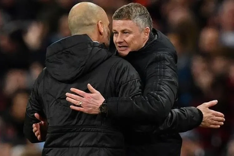 Manajer Manchester City, Pep Guardiola (kiri) bercengkerama dengan manajer Manchester United, Ole Gunnar Solskjaer pada laga leg kedua semifinal Piala Liga Inggris 2019/2020 di Etihad Stadium, Kamis (30/1/2020) dini hari WIB. [AFP]
