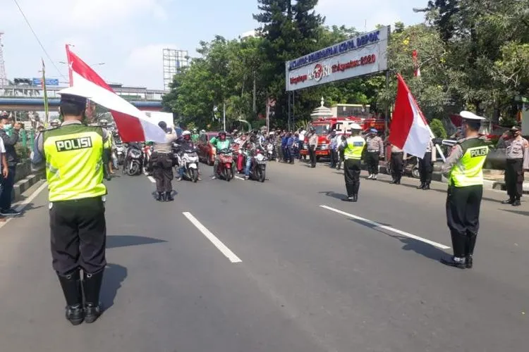 Peringati HUT Kemerdekaan RI ke-75 cukup mengharukan dilaksanakan aparat Polres Metro (Polrestro) Depok bersama pengendara kendaraan di setiap persimpangan di Jalan Margonda Raya, Kota Depok, Senin (17/8). Foto: Republika/Rusdy Nurdiansyah