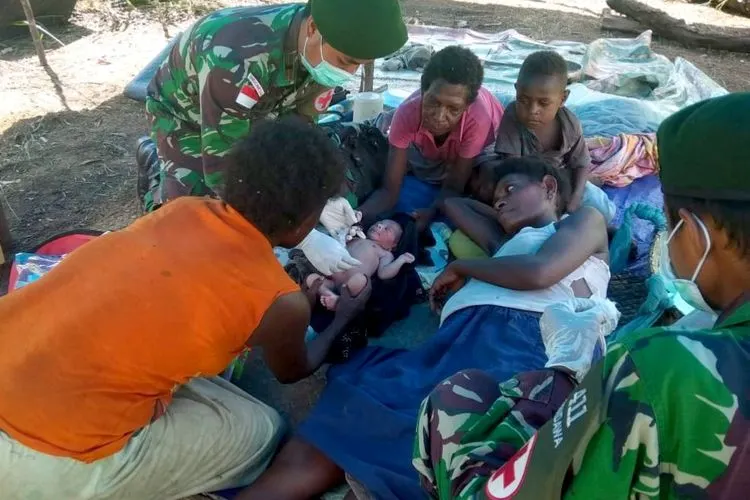 personel kesehatan Satgas Pamtas RI-PNG Yonif MR 411/Pdw Kostrad membantu persalinan Apolina Maywa (24) warga RT 03 Yakyu, Kampung Rawa Biru, Distrik Sota. (Puspen TNI)