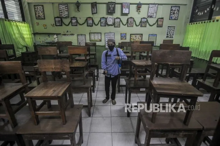 Petugas menyemprotkan cairan disinfektan di SDN 03 Kota Bambu, Tanah Abang, Jakarta. Sekolah tatap muka diwacanakan dibuka pada tahun ajaran Januari 2021.  Foto: Republika/Putra M. Akbar