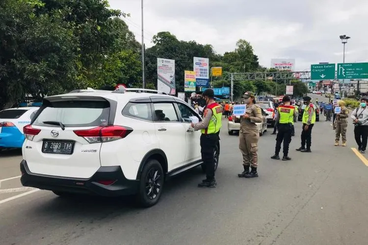 Petugas gabungan Satgas Covid-19 Kabupaten Bogor meminta surat hasil rapid test antigen kepada wisatawan yang hendak berangkat menuju Jalan Raya Puncak, Kamis (31/12). Foto: Republika/Shabrina Zakaria