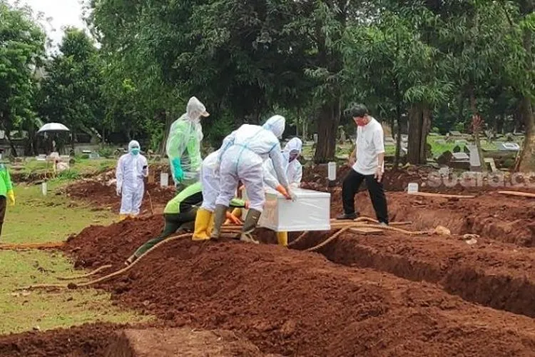 Penampakan petugas memakamkan jenazah pasien Corona di TPU Bambu Apus. (Suara.com/Bagaskara)