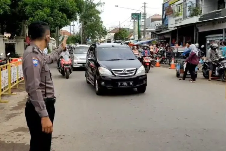 Polisi sedang mengatur lalu lintas di alun-alun Singaparna Kabupaten Tasikmalaya. Tampak dalam foto, kendaraan flat nomor B sedang melintas. (dok)