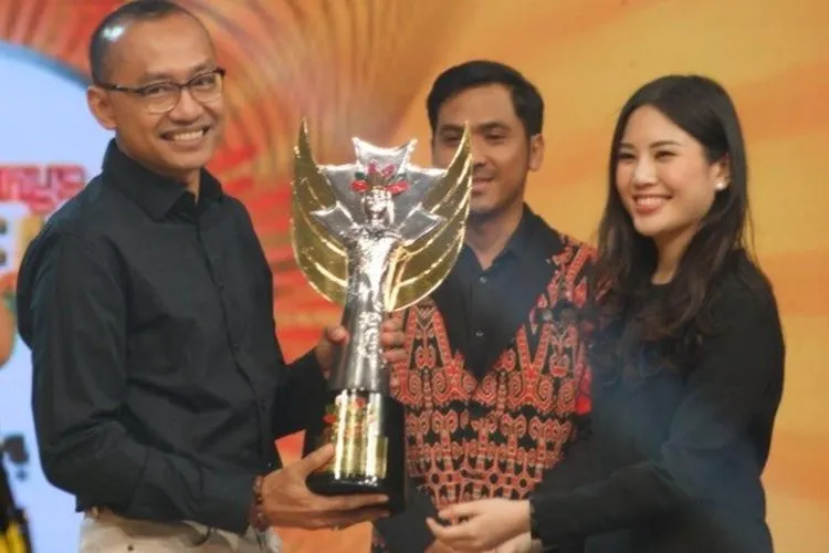 Wakil Menteri Pariwisata dan Ekonomi Kreatif, Angela Tanoesoedibjo, menyerahkan penghargaan kepada Kepala Bidang Seni Budaya Dinas Pariwisata dan Kebudayaan Provinsi DKI Jakarta Gumilar Ekalaya pada Minggu 17 November 2019  (iNews.id/Vien Dimyati)