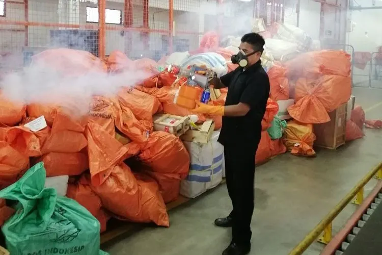 Karyawan menyemprotkan cairan disinfektan di areal Sentral Pengolahan Pos Surabaya/ (Dok. PT Pos Indonesia)