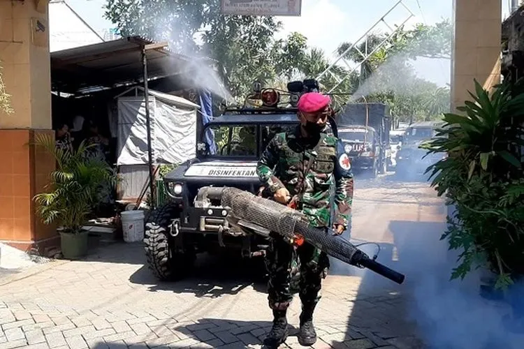 Prajurit Marinir Mako Menbanpur 2 Mar di bawah pimpinan Kapten Mar Heru melaksanakan pembagian sembako dan penyemprotan disinfektan mulai dari Perumahan dinas TNI AL Gunungsari, Jogoloyo, Wonokromo. (Marinir TNI AL)