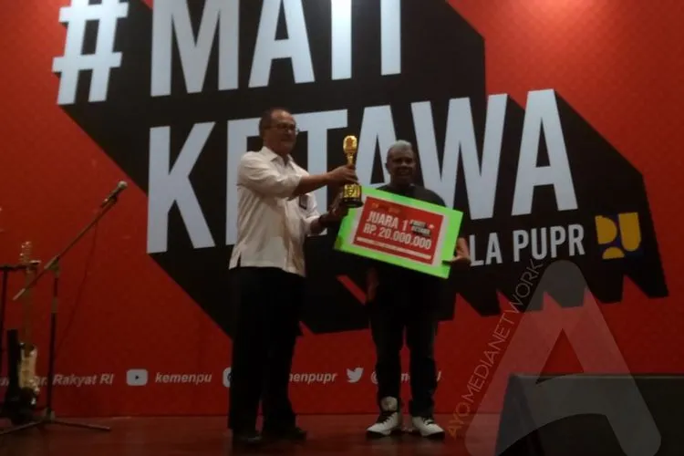 Reinold Lawalata menerima hadiah usai menjuarai Stand Up Competition Mati Ketawa Ala PUPR (Ayojakarta.com/Lopi Kasim)