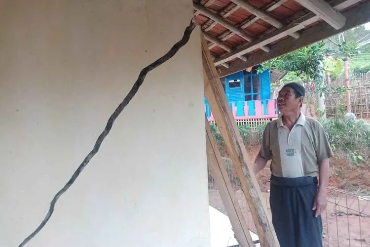Madin (56) Kampung Gandasoli, Desa Bojonggambir, Kecamatan Bojonggambir, Kabupaten Tasikmalaya saat melihat kondisi retakan rumahnya. (Ayotasik/Irpan Wahab)