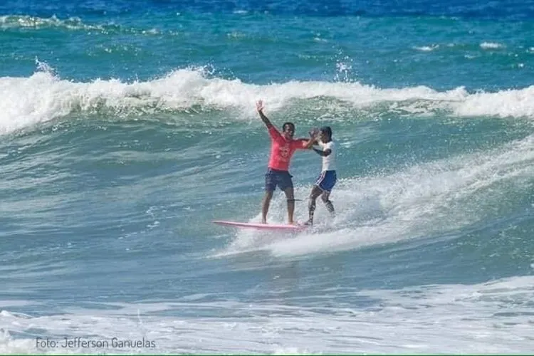 Aksi surfer Filipina, Roger Casugay, menolong Arip Nurhidayat saat keduanya berkompetisi memperebutkan medali emas di nomor longboard putra SEA Games 2019. (Foto: Twitter @Jokowi)