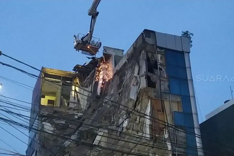Ruko minimarket Alfamart di Jalan Letjen Katamso, Slipi, Jakarta Barat yang ambruk pada Senin (6/1/2020) pagi mulai diratakan. (Suara.com/Tyo)