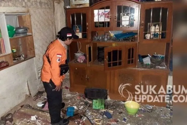 Petugas tampak tengah mengecek ruang tamu kediaman Rudiyansyah, warga Kampung Karamat RT 03/02 Desa Sukamaju, Kabupaten Sukabumi, Jawa Barat, yang rusak cukup parah akibat tersambar petir pada, Rabu (27/5/2020). (Ist)