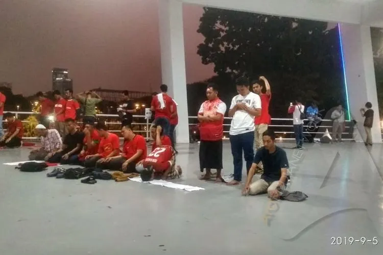 Kelompok suporter menggelar salat Maghrib berjamaah di SUGBK/Ayojakarta.com