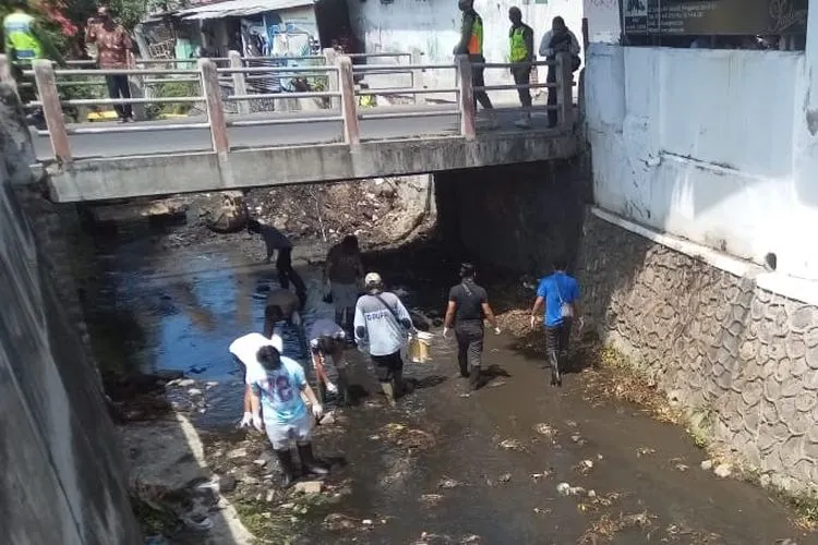 Sejumlah warga yang terjaring operasi yustisi masker membersihkan sungai selama 15 menit di Kota Solo, Senin (14/9/2020). (ist)