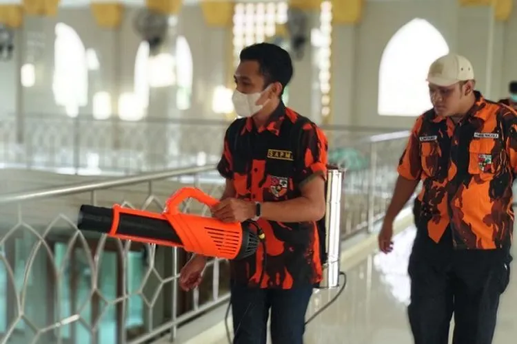 Satuan Siswa, Pelajar dan Mahasiswa Pemuda Pancasila (Sapma PP) Jakarta Timur bergotong royong menyemprot cairan disinfektan ke masjid