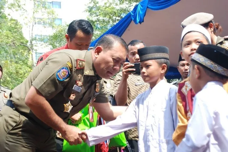 Kepala Satpol PP DKI Jakarta Arifin menyalami anak yatim penerima santunan/utara.jakarta.go.id