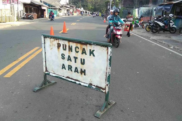 Papan pemberitahuan pemberlakuan arus lalu lintas satu arah di Jalur Puncak (Hendi/Radar Bogor)