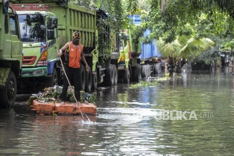 [ilustrasi] Seorang petugas membersihkan sampah dari saluran air saat terjadi banjir di kawasan Sunter, Jakarta Utara.  (Foto: Republika/Putra M. Akbar)