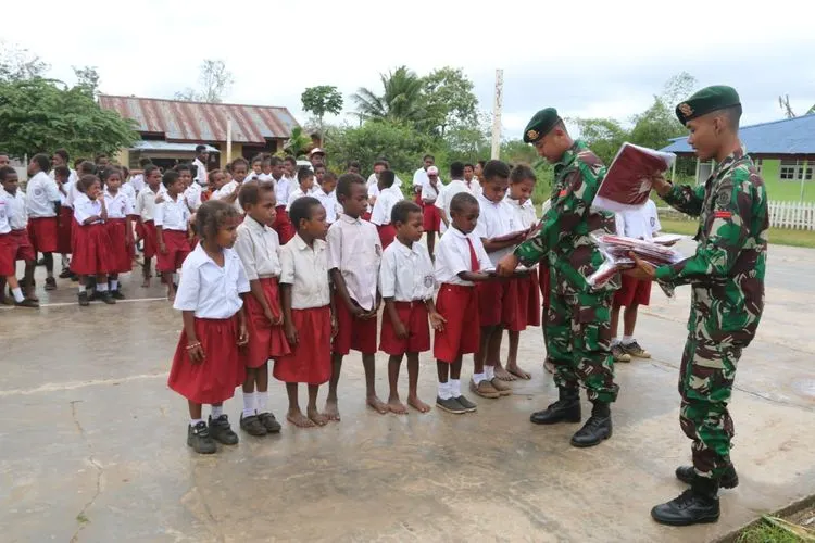 Satgas Pamtas RI-PNG bagikan seragam sekolah/Puspen TNI