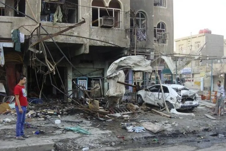 Warga menyaksikan bangunan dan mobil yang hancur akibat terkena serangan bom yang terus melanda Irak. Reuters