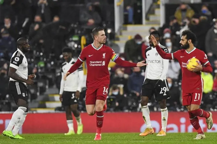 Striker Liverpool, Mohamed Salah (kanan) merayakan gol penyama kedudukan ke gawang Fulham pada laga Liga Inggris di Craven Cottage, Senin (14/12) dini hari WIB. Laga berakhir imbang 1-1.  (Foto: EPA/Neil Hall)
