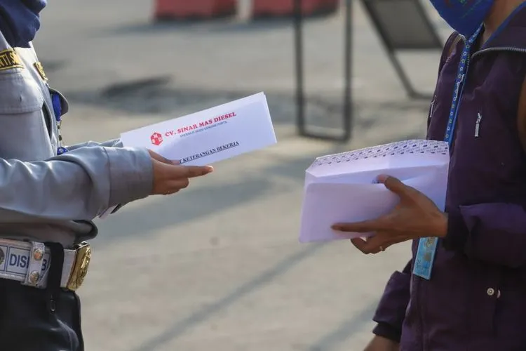 Sebagai ilustrasi, Petugas memeriksa surat tugas kantor para penumpang yang akan bekerja menggunakan transportasi Kereta Rel Listrik (KRL) di Stasiun Depok Baru, Depok, Jawa Barat, Jumat (15/5/2020). [Suara.com/Alfian Winanto]