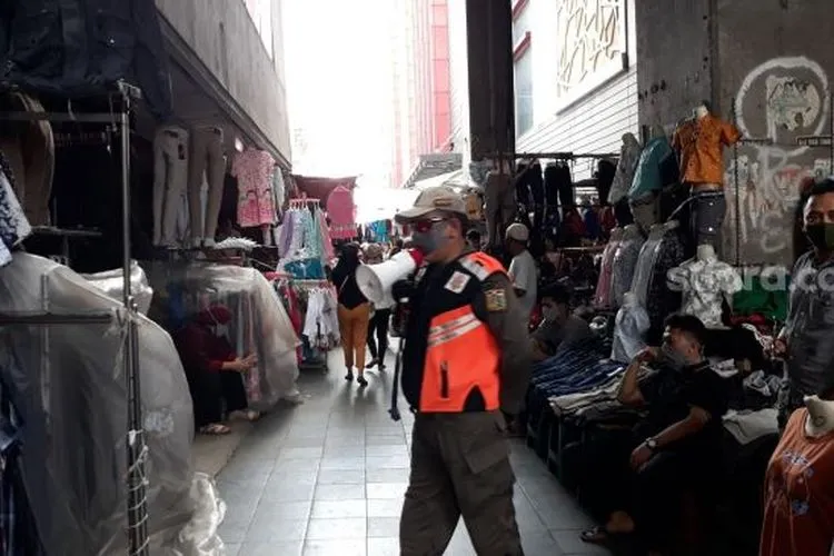 Sebagai ilustrasi: Petugas Satpol PP mengimbau warga yang ingin belanja di Pasar Tanah Abang saat PSBB untuk segera pulang. (Suara.com/Bagas)