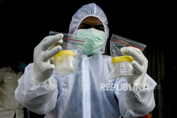 Petugas memperlihatkan wadah sampel dahak milik warga yang menjalani tes Polymerase Chain Reaction (PCR). Pemerintah Provinsi DKI Jakarta berupaya untuk meningkatkan kapasitas pemeriksaan metode RT-PCR. Foto: Republika/Putra M. Akbar