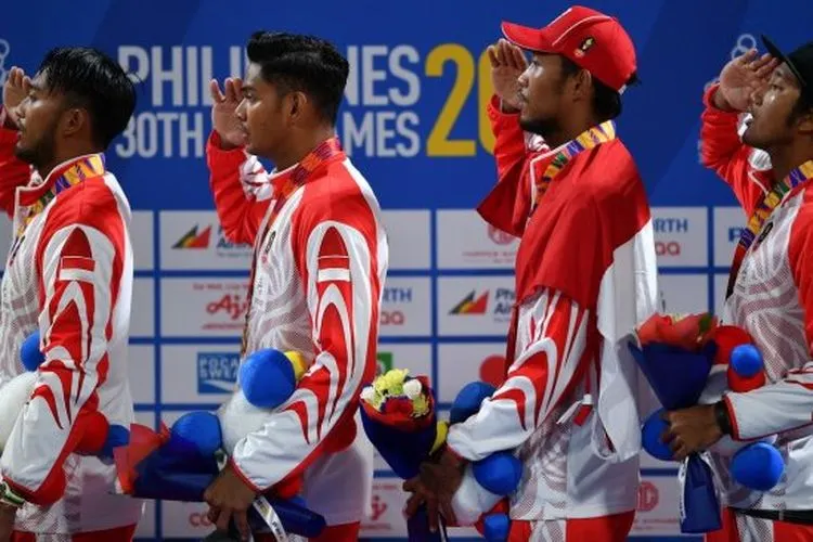 (Dari kiri) Tim bola voli pantai putra Indonesia Gilang Ramadhan, Danangsyah Pribadi, Ade Rachmawan dan Mohammad Ashfiya menyanyikan lagu Indonesia Raya saat penyerahan medali emas voli pantai beregu putra SEA Games 2019 di Subic Tennis Court, Subic, Filipina, Jumat (6/12/2019). (Antara/Sigid Kurniawan)