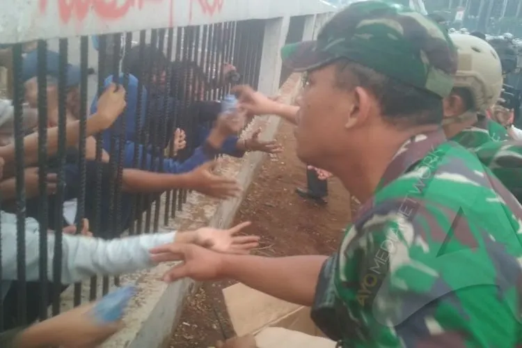Aparat TNI bagikan air minum ke mahasiswa di depan gedung DPR/Ayojakarta.com