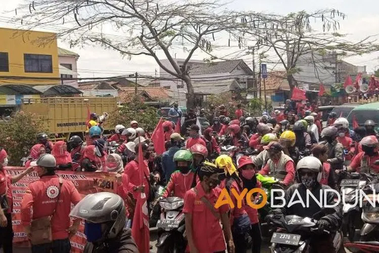 Ribuan buruh di Timur Kabupaten Bandung melakukan aksi blokir jalan di jalur Bandung-Garut, Rancaekek, sebagai bentuk penolakan penetapan Undang-undang Cipta Kerja, Selasa (6/10/2020) (Ayobandung.com/Mildan Abdalloh)