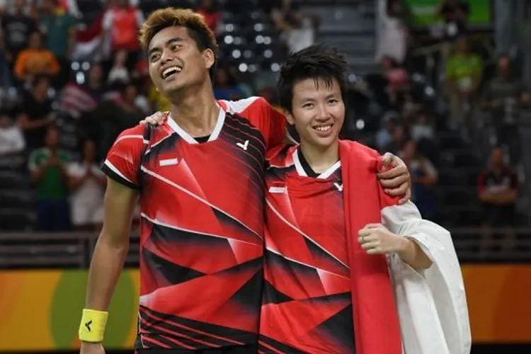 Pebulutangkis Indonesia, Tontowi Ahmad (kiri) bersama partnernya di ganda campuran, Liliyana Natsir, merayakan keberhasilan meraih medali emas di Olimpiade 2016 Rio de Janeiro. [AFP/Goh Chai Hin]
